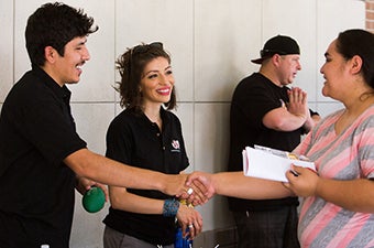 Members of a student organization greeting guests during a campus tabling event