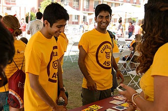 Two students getting information from a table during an event