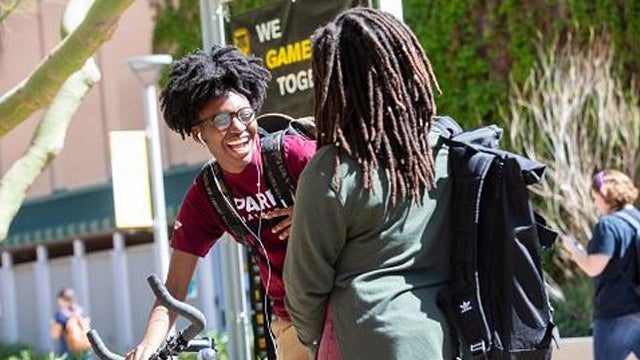 Two Sun Devil students stop and chat near the Memorial Union on the Tempe campus.